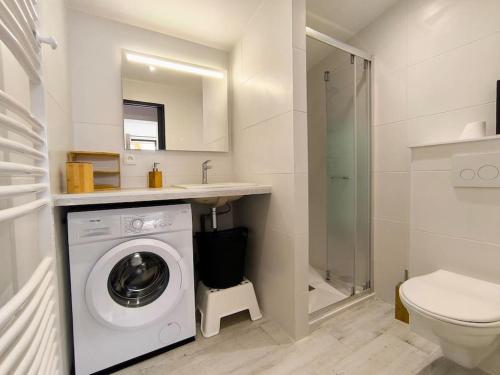 La salle de bains blanche est pourvue d'un lave-linge et de toilettes. dans l'établissement La Cabane C7, à Andernos-les-Bains