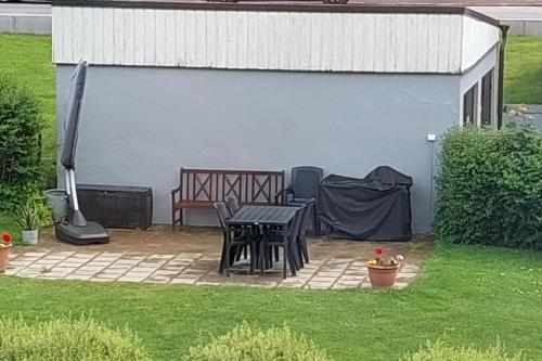 a patio with a table and a bench in a backyard at Fin lägenhet i Ulricehamn nära Lassalyckan in Ulricehamn