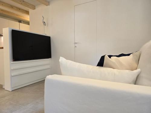 a white living room with a tv and a couch at SardiniaSeaHouse in Pula
