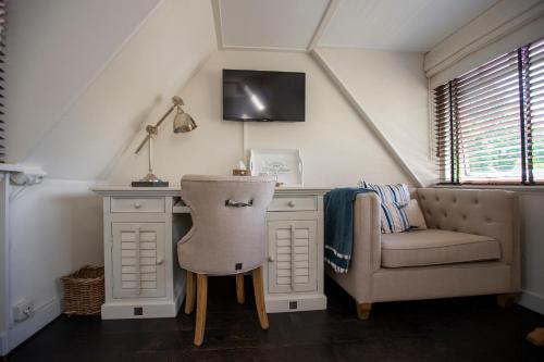 a room with a desk with a chair and a chair at Zenzez Hotel & Lounge in Apeldoorn
