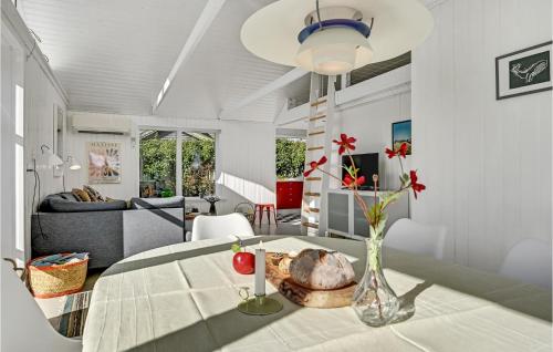 a living room with a table with a vase of flowers at One-Bedroom Holiday Home In Hornslet in Hornslet