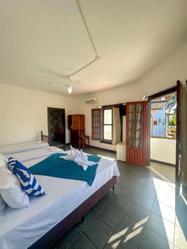 a bedroom with a large bed with blue sheets at Pousada Sol Nascente in Paraty