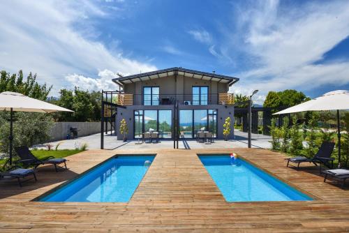 a villa with a swimming pool and a house at Olive All-Seasons Suites, Panel Hospitality Homes & Villas in Litochoro