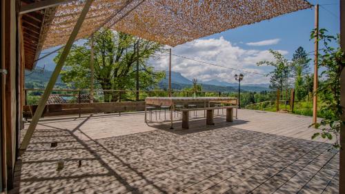 a picnic table on a patio with mountains in the background at Au son du Diois - Gîte de groupe et familial - Die in Die