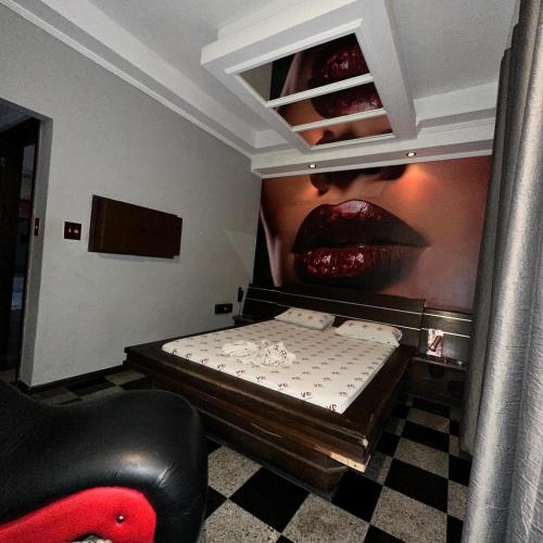 a room with a bed with a poster of a woman at Motel Vitória Reggia in São Vicente