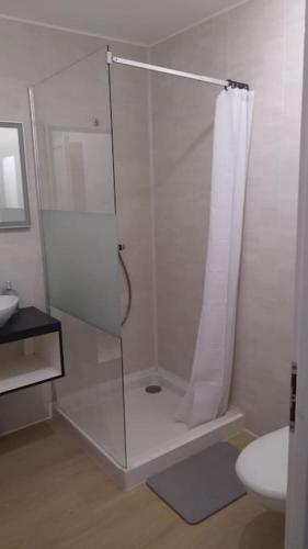 une salle de bain blanche avec une douche et un lavabo dans l'établissement Maison à la campagne, à Les Brouzils