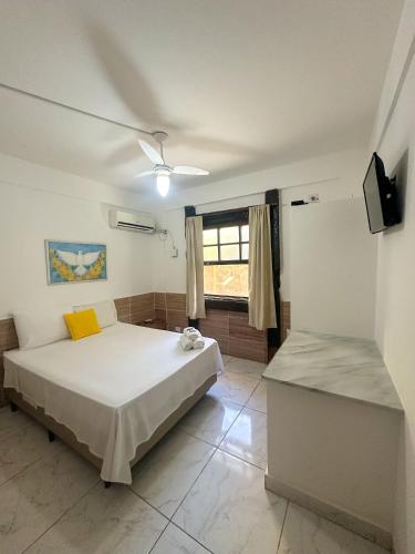 a bedroom with a large bed and a window at Pousada Sol Nascente in Paraty