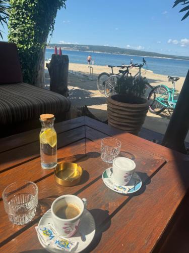 a wooden table with two cups of coffee and a view of the beach at Lux dodo in Dramalj