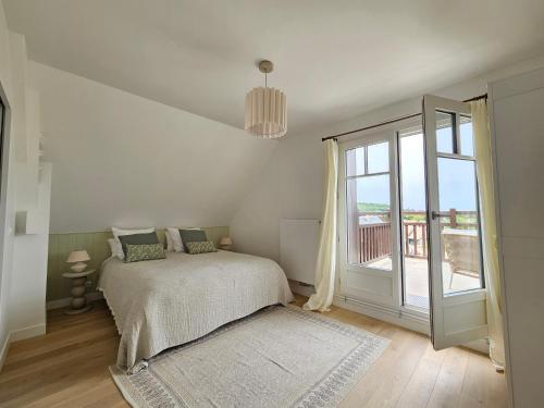 une chambre avec un lit et une grande fenêtre dans l'établissement Superbe villa familiale, 8 couchages, à Deauville