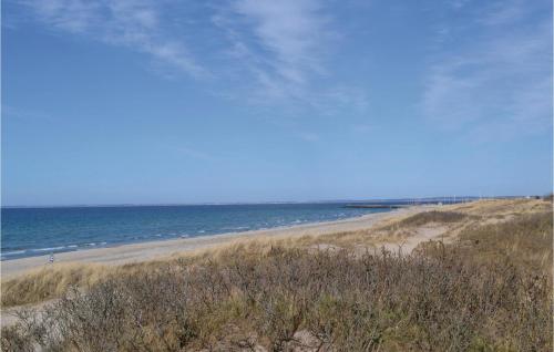 a sandy beach with the ocean in the background at Apartment Kystvej Hornbæk Ii in Hornbæk