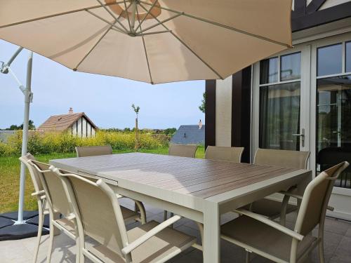 une table et des chaises avec un parasol sur une terrasse dans l'établissement Superbe villa familiale, 8 couchages, à Deauville