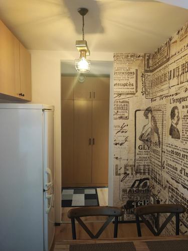 a kitchen with two chairs and a wall with newspapers at Blackwood Hill in Belgrade