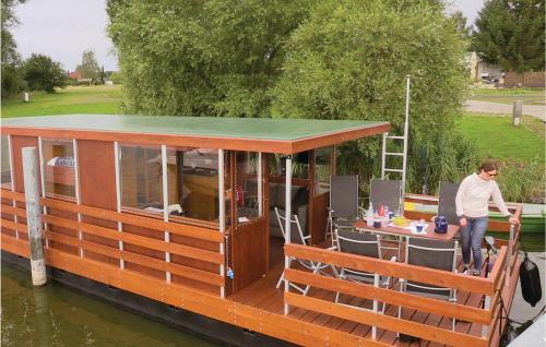 un uomo in piedi su una barca con un tavolo sul ponte di 2 Bedroom Amazing Ship In Radewege a Radewege