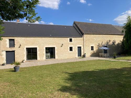 - un grand bâtiment en briques avec une pelouse dans l'établissement LES HIRONDELLEs, à Courcy