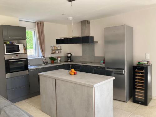 une cuisine avec des appareils en acier inoxydable et un comptoir dans l'établissement LES HIRONDELLEs, à Courcy