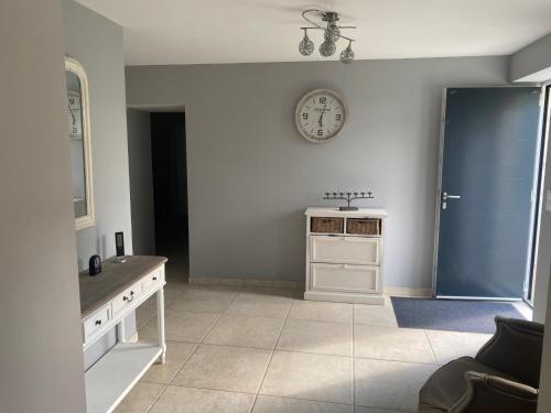 une cuisine avec une horloge murale et un évier dans l'établissement LES HIRONDELLEs, à Courcy