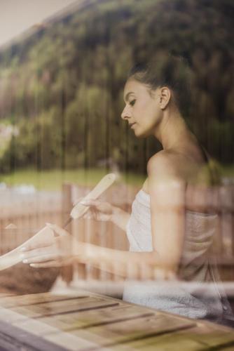 a woman sitting in a bath tub reading a book at Luxury Chalet Milé in Ortisei