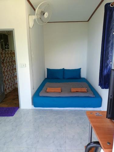 a blue bed in a room with a fan at Nuea Tawan at Phu Thap Buek in Ban Tha Kok Hai
