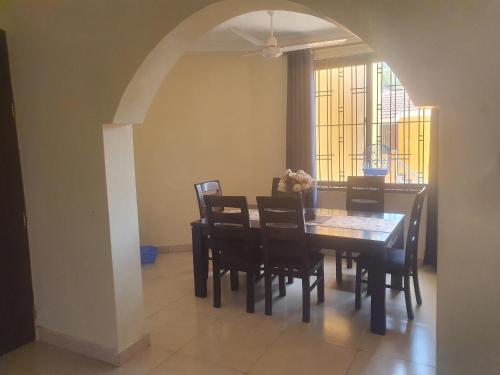 Un comedor con mesa y sillas en HOME TO STAY Apartments, en Mombasa