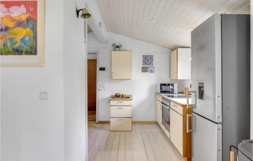 a kitchen with white cabinets and a refrigerator at Awesome Home In Jægerspris With Kitchen in Jægerspris