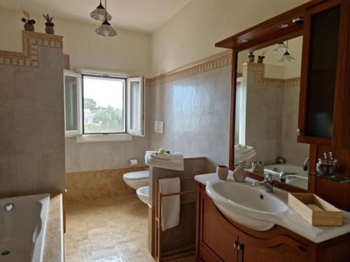 a bathroom with two sinks and a toilet and a tub at Residenza "I Tre Carrubi " in Fasano