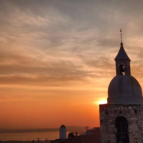 a church steeple with the sunset in the background at Amazing Gargano in Ischitella