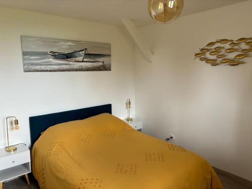- une chambre dotée d'un lit jaune et d'une peinture murale dans l'établissement Appartement II style industriel, à Valliquerville
