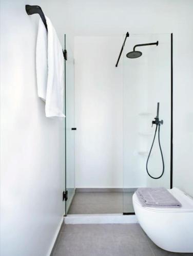 a white bathroom with a shower and a toilet at Lavender House in Kampos Paros