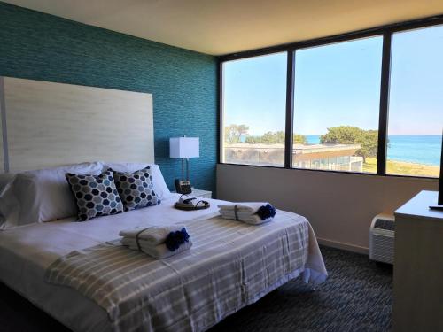 a bedroom with a bed with a view of the ocean at Illinois Beach Hotel in Zion