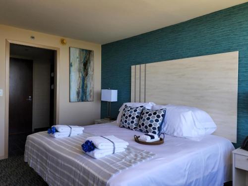 a bedroom with a large white bed with towels on it at Illinois Beach Hotel in Zion