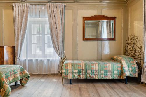 a room with two beds and a mirror and a window at Chateau Ciasa Soldà Luxe Saslonch in Vigo di Fassa