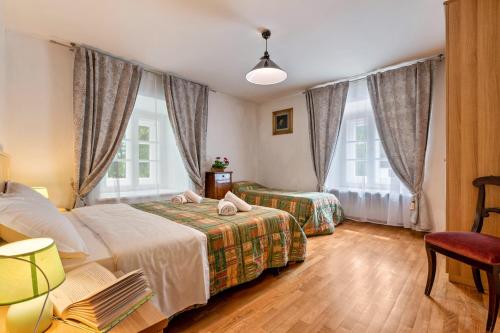 a hotel room with two beds and a chair at Chateau Ciasa Soldà Luxe Saslonch in Vigo di Fassa