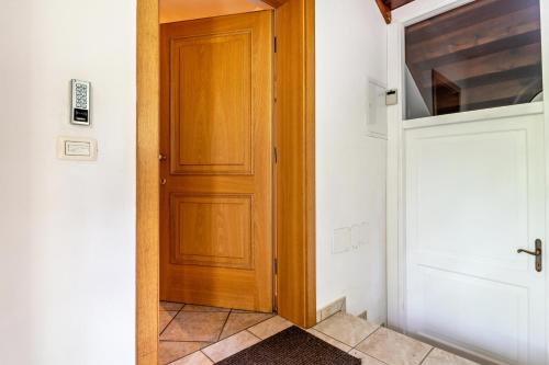 a wooden door in a room with a tile floor at Chateau Ciasa Soldà Luxe Saslonch in Vigo di Fassa