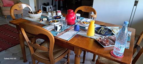 une table en bois avec de la nourriture et des bouteilles dessus dans l'établissement Jardin des Chats, à Sévignacq-Meyracq