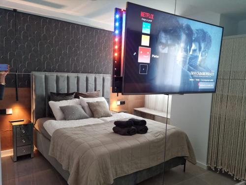 a bedroom with a bed with a large screen on it at "BOUTIQUE H8" Beach Roof Terrace Infinity Pool Bar SPA Padel Swimming Pool in Canet de Berenguer