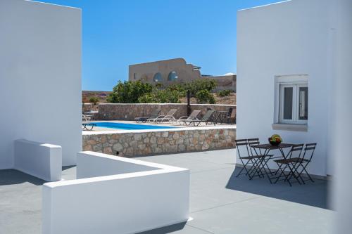 a patio with a table and chairs and a pool at Grand Village in Imerovigli