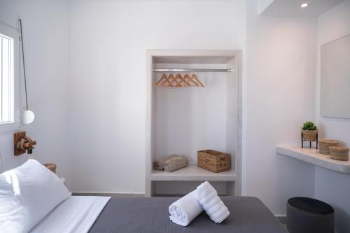 a bedroom with a bed with two towels on it at Grand Village in Imerovigli