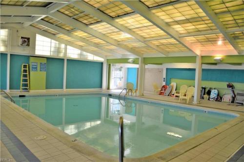 a large swimming pool in a large room with at Oceanfront condo, ocean view and indoor pool in Virginia Beach