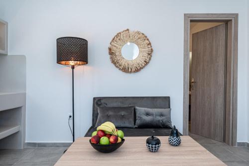 a room with a table with a bowl of fruit on it at Grand Village in Imerovigli
