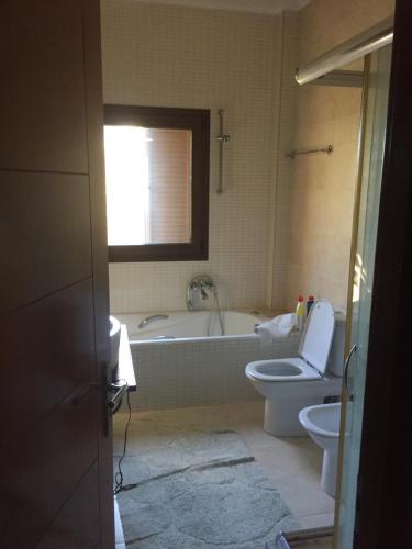 a bathroom with a tub and a toilet and a sink at Il TRAMONDO in Néa Thésis