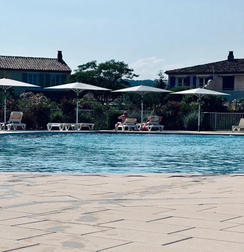 une piscine avec chaises et parasols dans l'établissement Studio Apartment - Domaine du Golf Resort, à Roquebrune-sur Argens