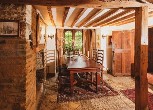 una sala da pranzo con tavolo in legno in una stanza di Lyne House Ideal for a celebration or reunion a Kidlington