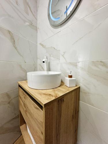 a bathroom with a white sink on a wooden counter at PENSION MYD La Vega in Oviedo