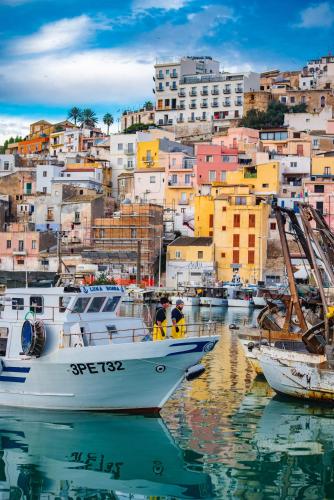 a group of boats docked in a harbor with buildings at VitaLenta Rooms & Apartments in Sciacca
