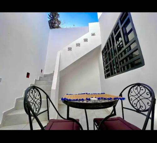 a table and two chairs and a table and stairs at Maison confortable Cosy et terrase prive à Marrakech in Marrakech
