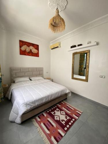 a bedroom with a bed and a mirror and a rug at Maison confortable Cosy et terrase prive à Marrakech in Marrakech