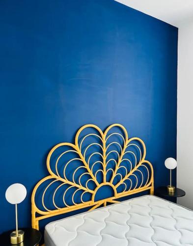 - une chambre bleue dotée d'un lit avec un mur bleu dans l'établissement Cocon à 5 mn du circuit des 24h, au Mans