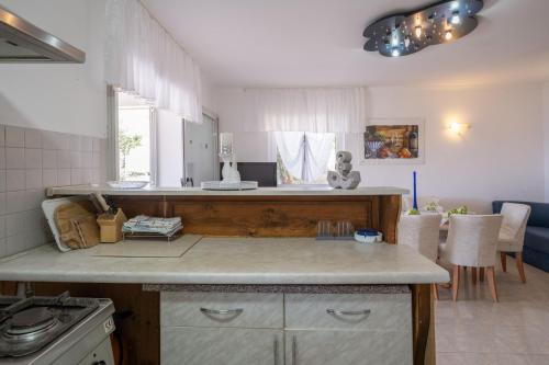 een keuken met een aanrecht en een tafel bij Apartmani Marelic - Sun Beach in Zavalatica