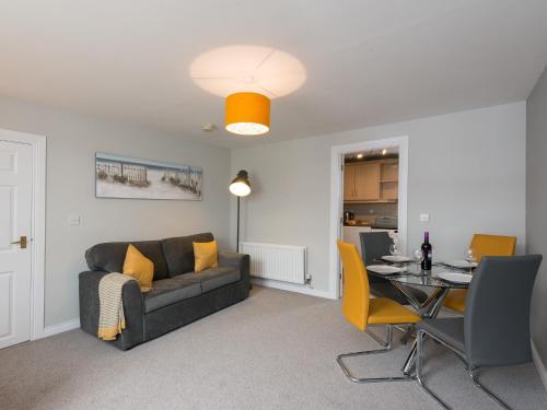 a living room with a couch and a table at Hamilton House Holiday Apartment in Killyleagh