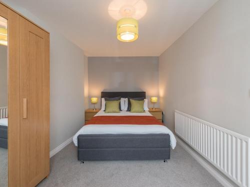 a bedroom with a bed with a red blanket at Hamilton House Holiday Apartment in Killyleagh